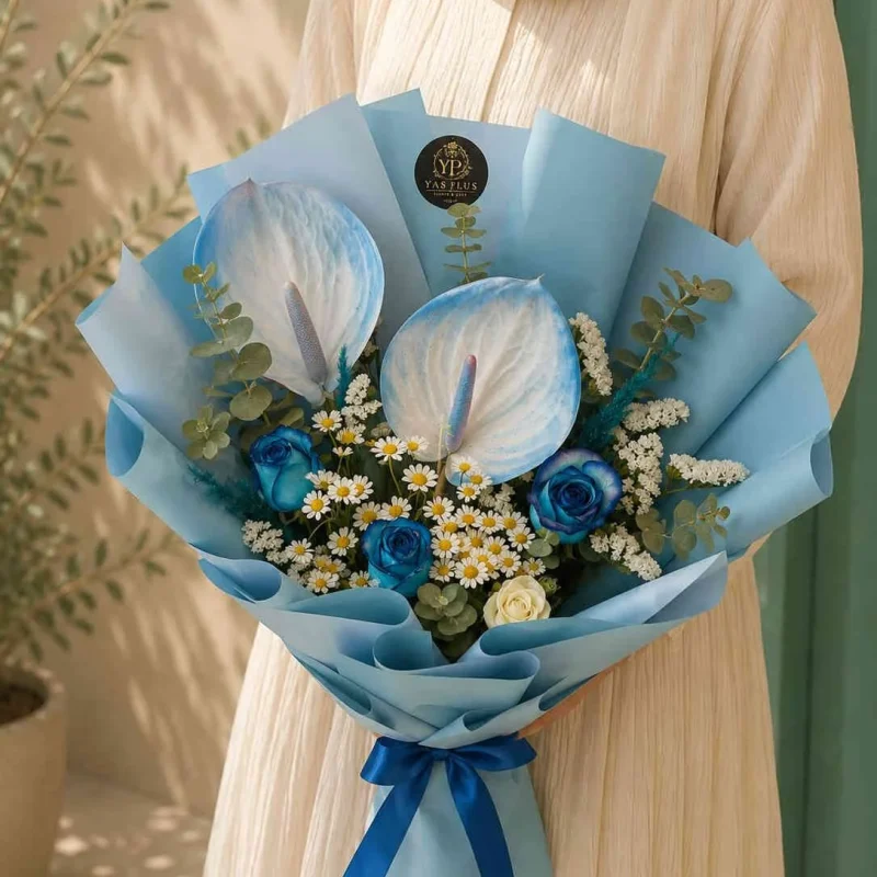 دسته گل لوکس آنتوریوم سفید و رز آبی با گل‌های بابونه و بسته‌بندی آبی یاس پلاس