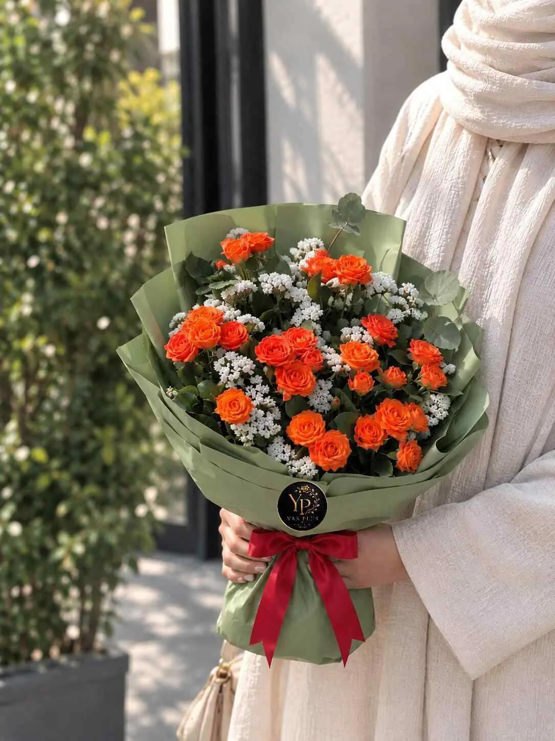 poneh-orange-rose-flower-bouquet.jpg دسته گل رز نارنجی و گل عروس سفید با کاغذپیچ سبز زیتونی و پاپیون قرمز